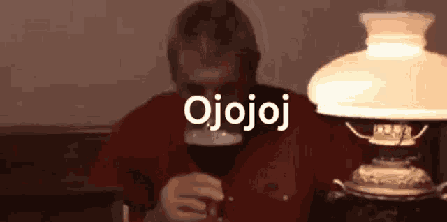 a man is sitting at a table drinking a glass of beer .