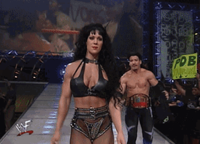 a man and a woman are walking down a runway with a sign that says pdb in the background