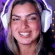 a woman is wearing headphones and smiling while playing a video game .