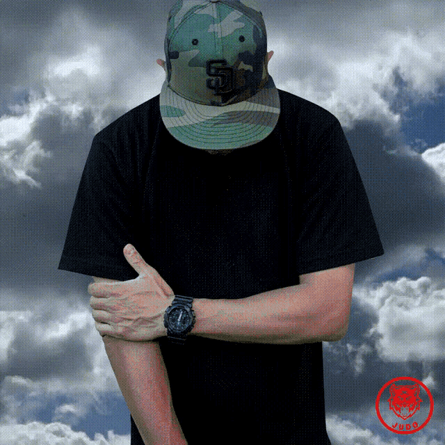 a man wearing a camouflage hat with the letter s on it