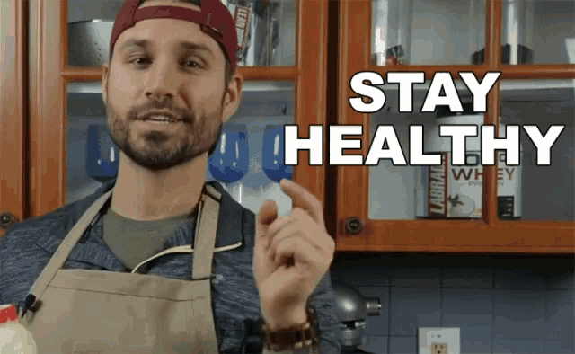 a man in an apron is holding a pill with the words stay healthy behind him