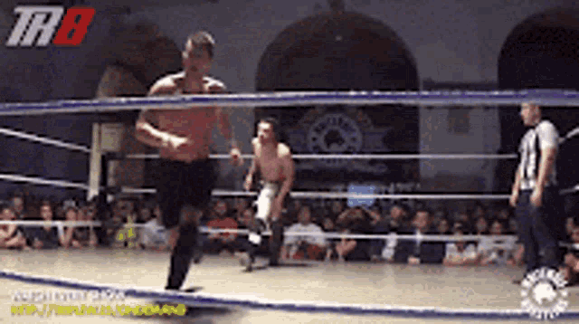 two men are wrestling in a ring with the letters thb on the bottom right