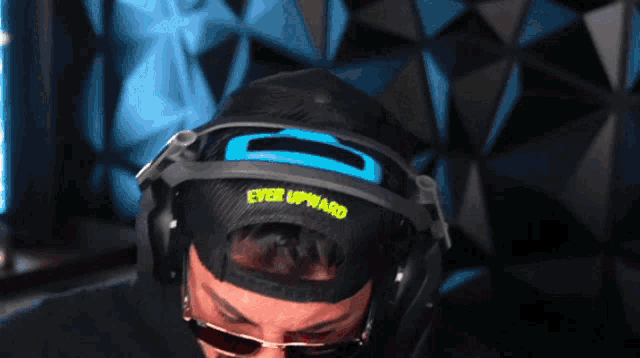 a man wearing headphones and a hat that says ever upward on it