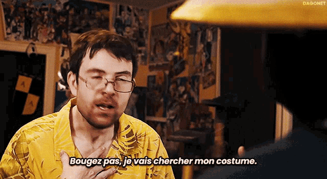 a man wearing glasses and a yellow shirt says bougez pas