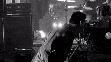a man playing a guitar in front of a tama drum