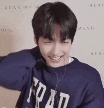 a young man wearing headphones and a blue sweatshirt is laughing .