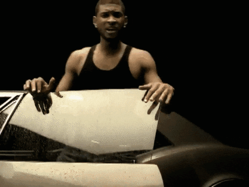 a man is holding the hood of a car