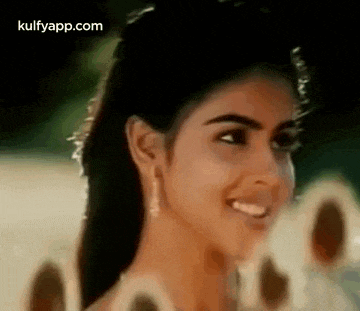 a close up of a woman 's face with a smile on her face and a blurred background .