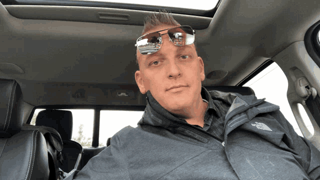 a man wearing sunglasses is sitting in a car