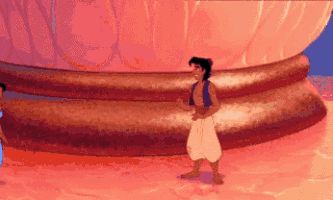 a cartoon character from aladdin is standing in front of a large statue .