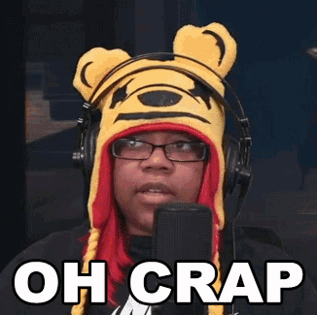 a woman wearing a winnie the pooh hat and headphones is speaking into a microphone .