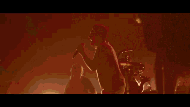 a man singing into a microphone in front of a crowd of people