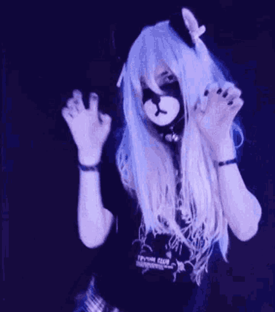 a woman with long blue hair is giving the middle finger .