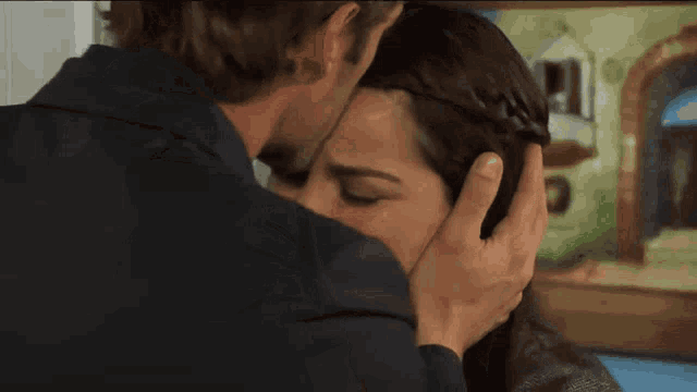 a man touches a woman 's forehead with his hand
