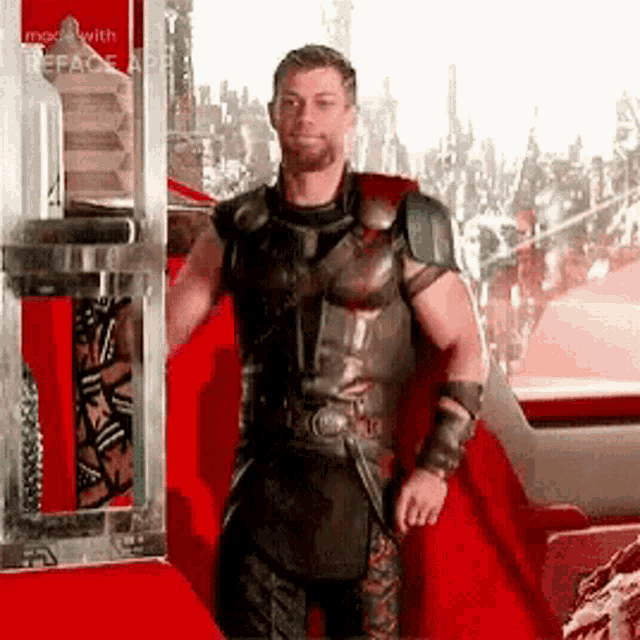 a man in a superhero costume with a red cape is standing in front of a window .
