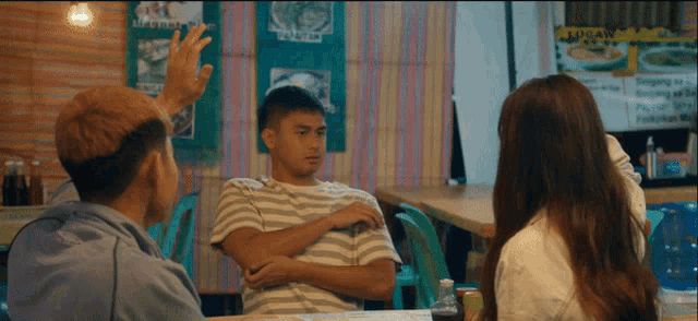 a group of people are sitting at a table in front of a sign that says lagyan