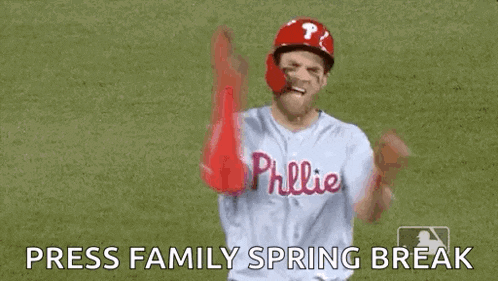 a baseball player is standing on a field with his arms in the air and a caption that says `` press family spring break '' .