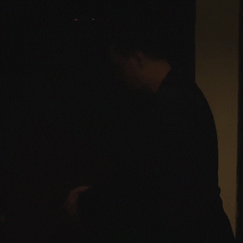 a shadow of a man is cast on a wall in a dark room