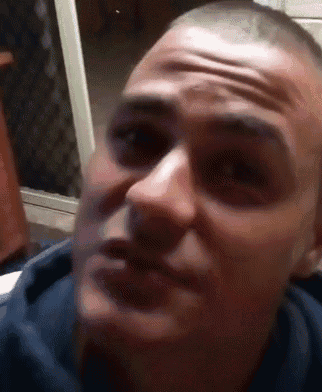 a close up of a man 's face with a shaved head making a funny face