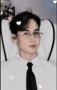 a man wearing glasses and a tie is laying on a white couch