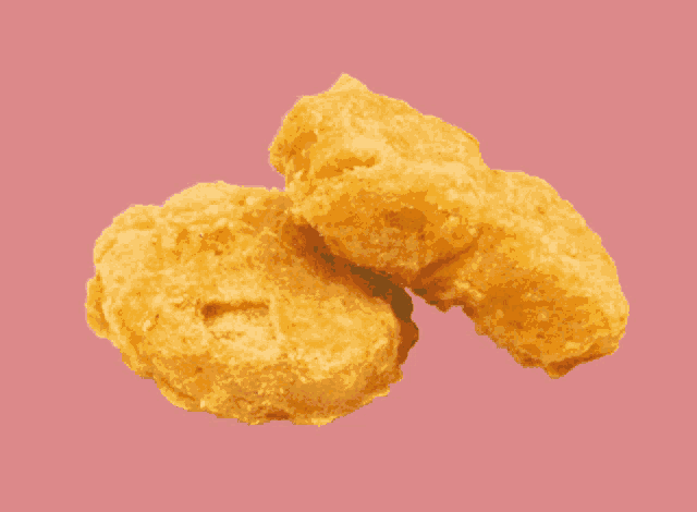 two chicken nuggets on a green background