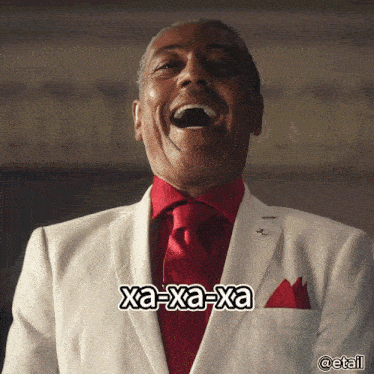 a man in a white suit and red tie is laughing with xa-xa-xa written on the bottom