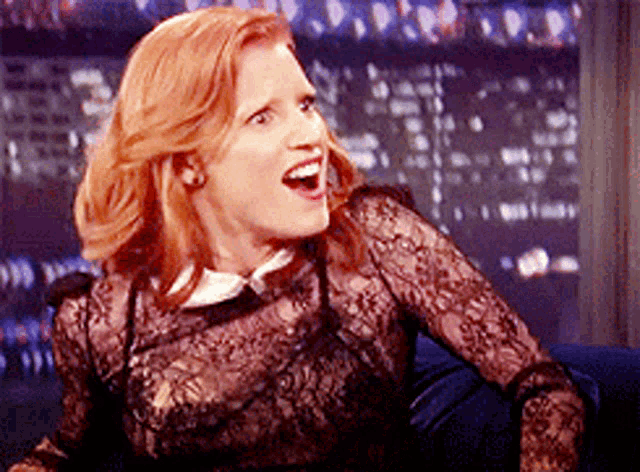 a woman in a black lace top is laughing