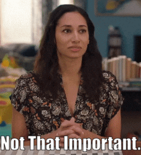 a woman in a floral shirt is sitting at a table with a sign that says not that important