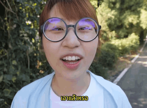 a woman wearing glasses and a white shirt with a yellow sticker that says " aa " on it