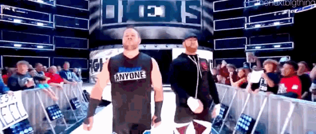 a wrestler wearing a shirt that says anyone walks down a ramp