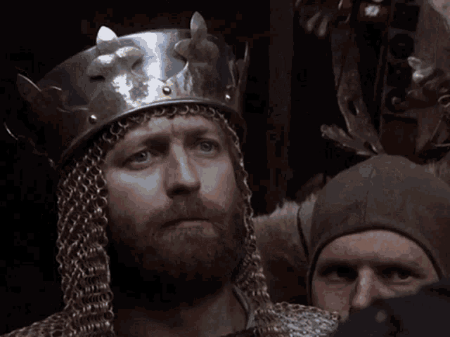 a man in a knight 's helmet stands next to a sign that says you make