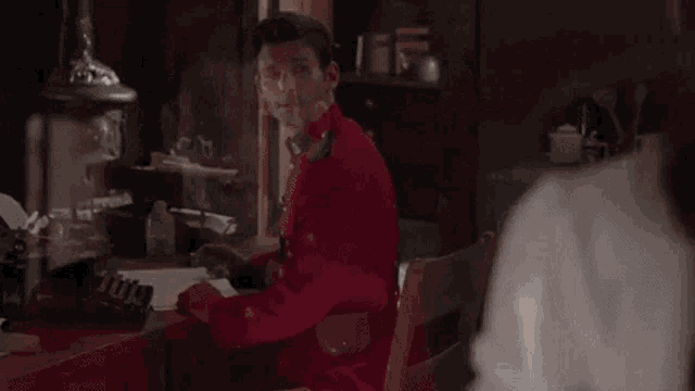 a woman in a white shirt is talking to a man in a red shirt .