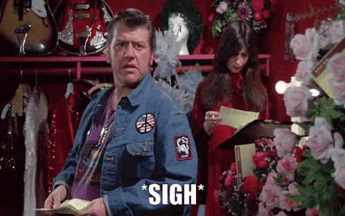 a man in a denim jacket is standing in front of a woman holding a clipboard and the word sigh is above him