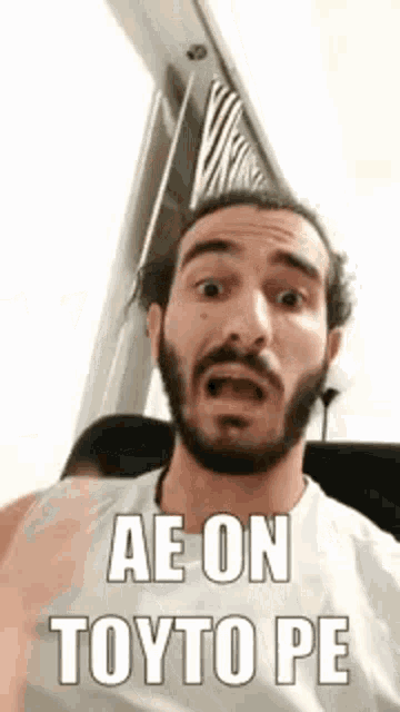 a man with a beard is making a funny face while sitting on a bus .