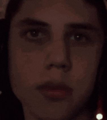 a close up of a person 's face in the dark with a blurred background .