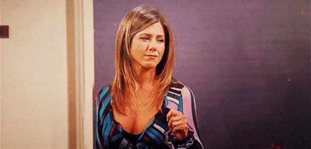 a woman in a striped dress is standing in a doorway holding a piece of paper .