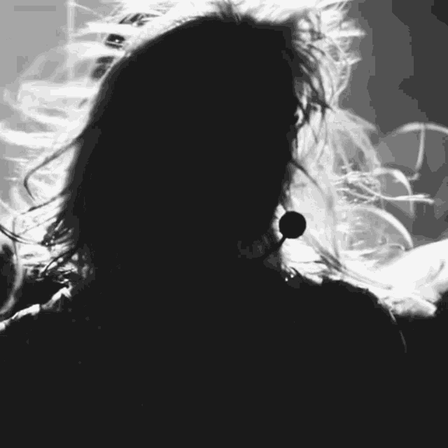 a black and white photo of a woman with a microphone in her ear .