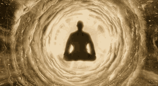 a silhouette of a person in a lotus position in a tunnel of light