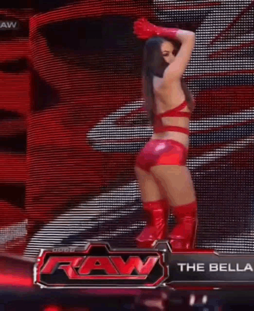 a woman in a red outfit is standing on a stage in front of a large screen .