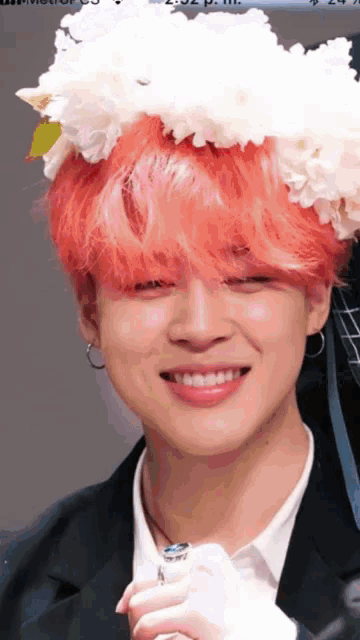 a close up of a person with pink hair wearing a flower crown