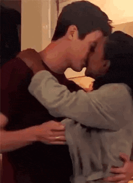 a man and a woman are kissing and hugging each other .