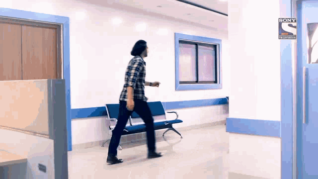 a man is walking down a hallway with a sign that says sony