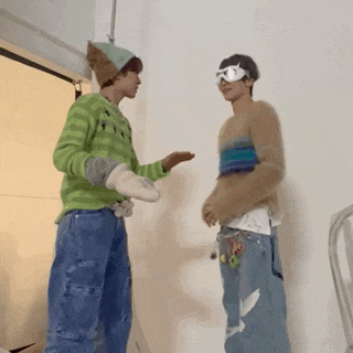 two men are standing next to each other in a room .