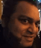 a man with a beard is making a funny face in a close up of his face .