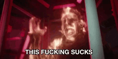a ghost is appearing in a dark room with the words `` this fucking sucks '' written below it .