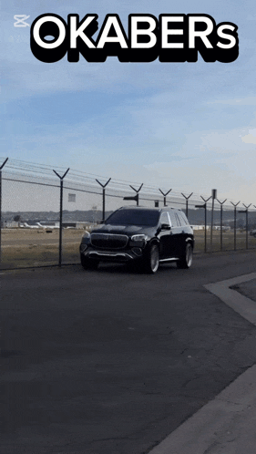 a car is driving down a road with okabers written on the top