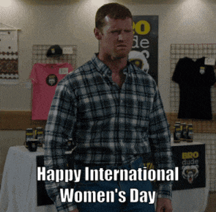 a man in a plaid shirt stands in front of a table with the words happy international women 's day on it