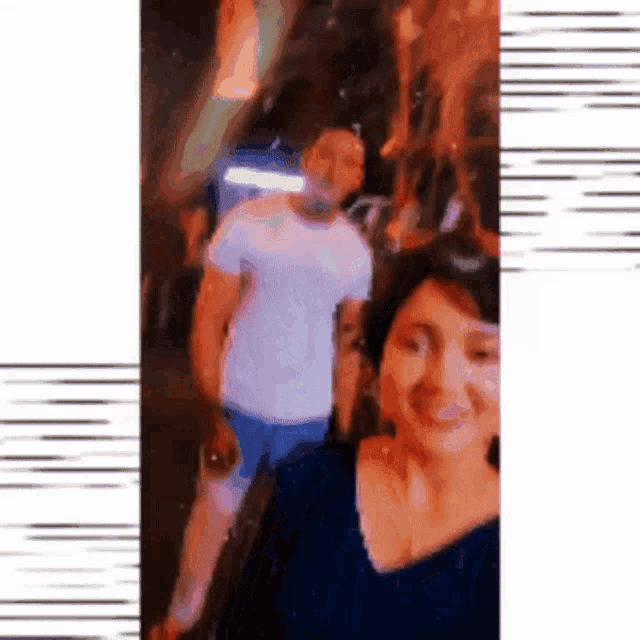 a blurry picture of a man and a woman standing next to each other .