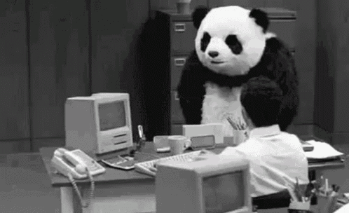 a panda bear is standing over a man sitting at a desk .