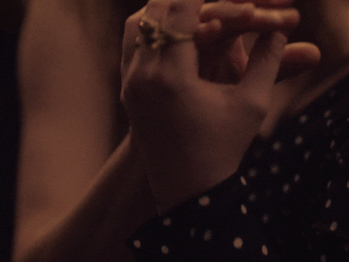 a woman 's hand with a ring on it